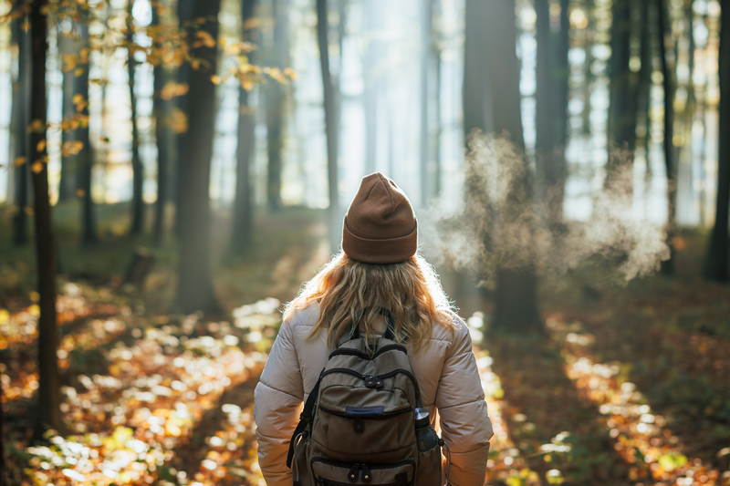 woman hiker in the woods wearing winter attire and a backpack