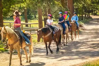 family horseback riding in the mountains