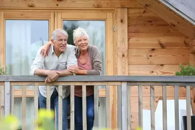 A happy couple on the deck of a cabin rental.