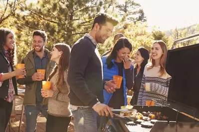 A group of friends enjoying a cookout on a deck.