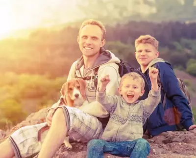 A family with a dog in the mountains.