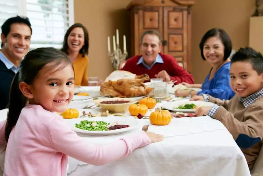 Happy family enjoying Thanksgiving dinner at one of our vacation rentals in Murphy NC.