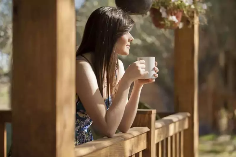 Woman enjoying a cup of coffee on the porch of one of our Murphy North Carolina vacation rentals.