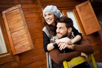 Man and woman embracing at their romantic 1 bedroom North Carolina cabin.