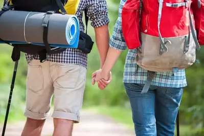 Couple hiking in the woods near their romantic 1 bedroom North Carolina cabin.