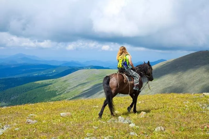 Woman horseback riding in the mountains