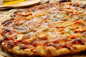 A tasty pizza with pieces of chicken.