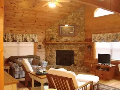 A living room with a stone fireplace at a Murphy North Carolina cabin rental.